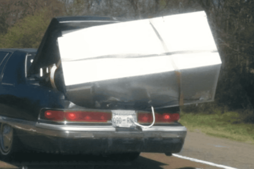 Moving a fridge by sticking it partially in a car trunk