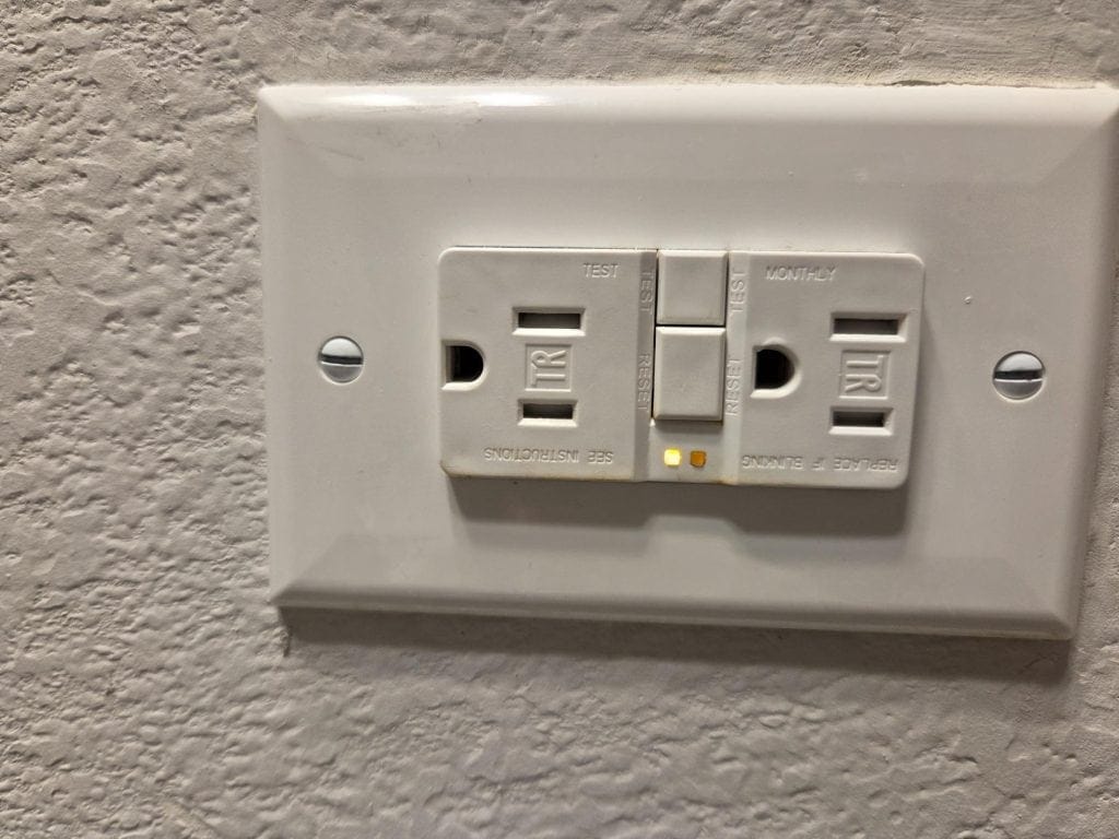 Tripped GFCI outlet showing amber LED indicator